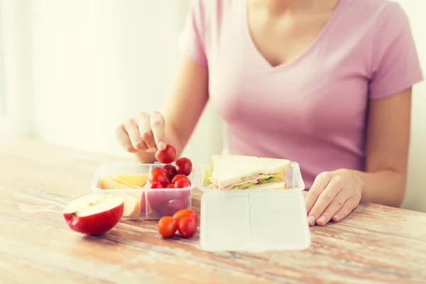 Close up of woman with food in plastic container — Stock Photo, Image