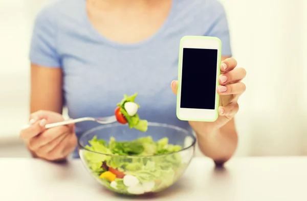 Close up of woman with smartphone eating salad — Stock Photo, Image