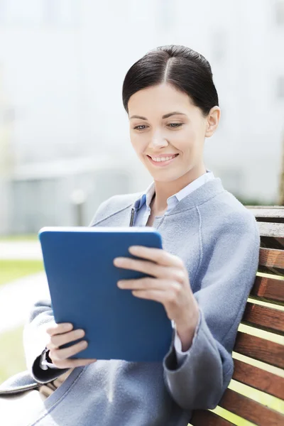 Sonriente mujer de negocios con tablet pc en la ciudad —  Fotos de Stock