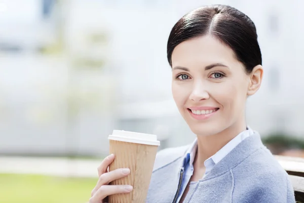 Leende kvinna dricka kaffe utomhus — Stockfoto