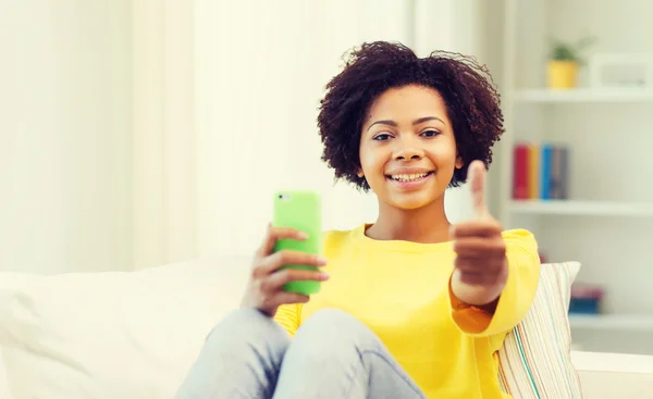 Happy african woman with smartphone at home — Stock Photo, Image