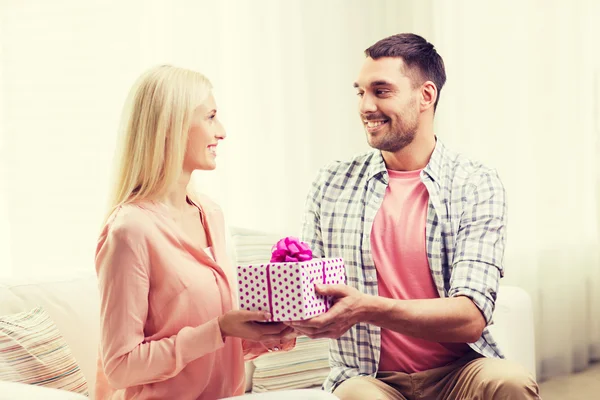 Szczęśliwy człowiek daje kobieta w domu pudełko. — Zdjęcie stockowe