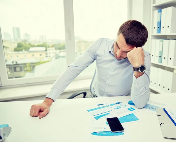 Stressad affärsman med papper i office — Stockfoto