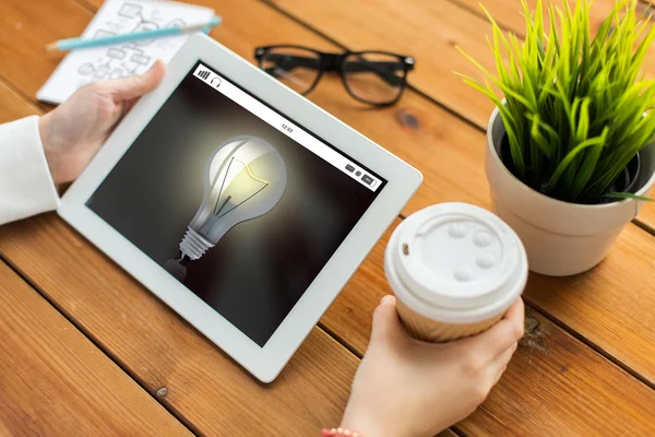 Close up of woman with light bulb on tablet pc — Stock Photo, Image