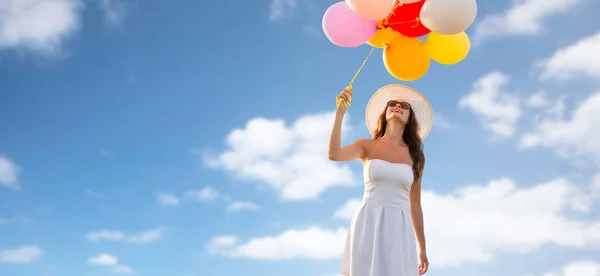 Lachende jonge vrouw in zonnebril met ballonnen — Stockfoto