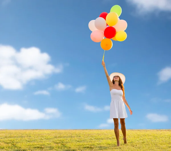 Sorrindo jovem mulher em óculos de sol com balões — Fotografia de Stock