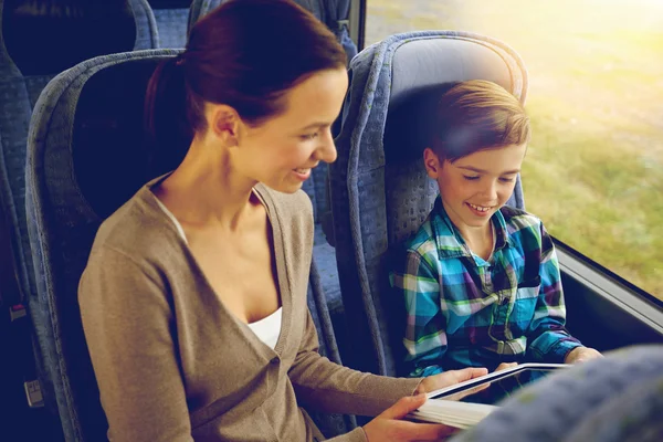 Happy family with tablet pc sitting in travel bus — Stock Photo, Image