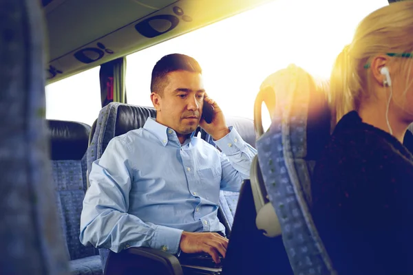 Muž s smartphone a notebook v cestování autobusem — Stock fotografie