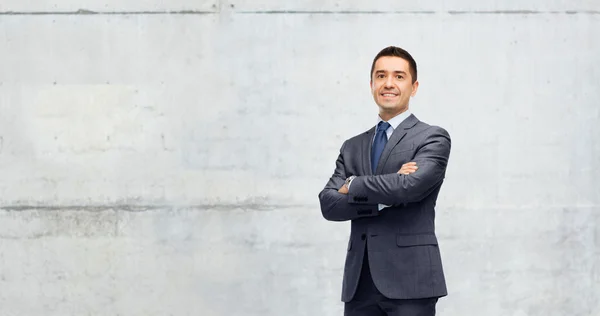 Glücklich lächelnder Geschäftsmann über graue Betonwand — Stockfoto