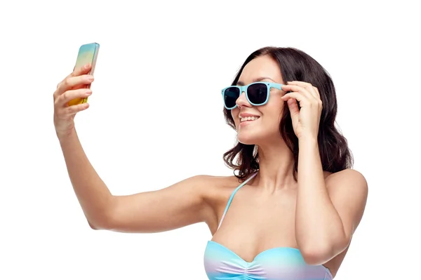Женщина в купальнике делает селфи со смартфоном — стоковое фото