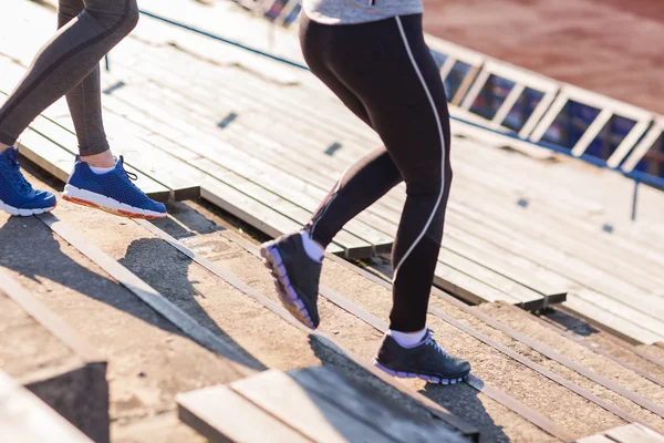 Close up of couple running downstairs on stadium — Stock Photo, Image