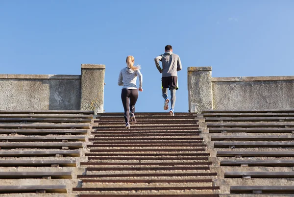 Couple running upstairs on stadium — Stock Photo, Image