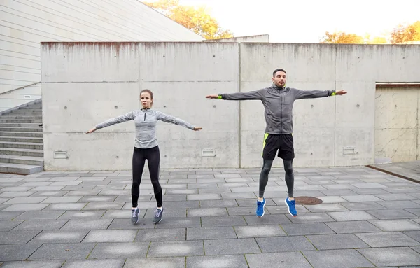 Feliz hombre y mujer saltando al aire libre — Foto de Stock