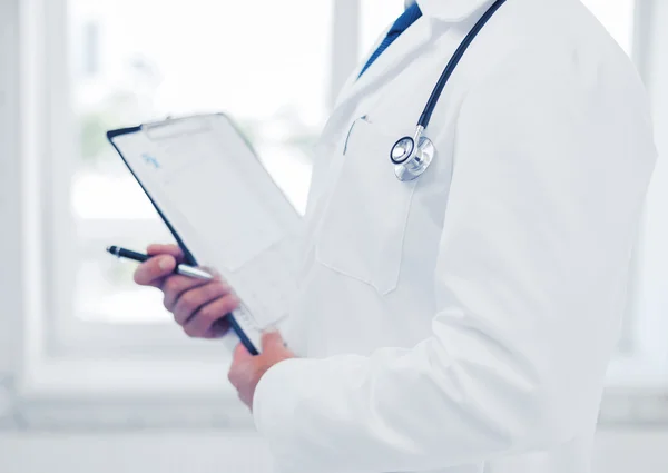 Male doctor with stethoscope writing prescription — Stock Photo, Image