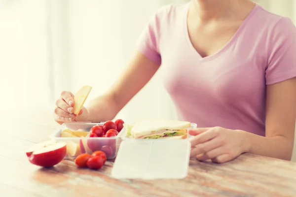 Close up of woman with food in plastic container — Stock Photo, Image