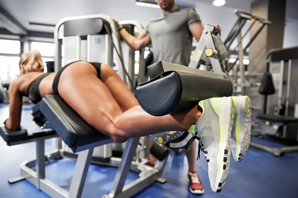 Homme et femme flexion muscles sur la machine de gymnase — Photo