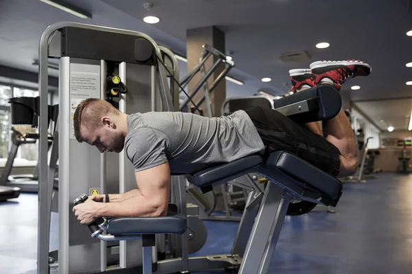 Adam spor makinesinde bacak kaslarını esnetiyor. — Stok fotoğraf