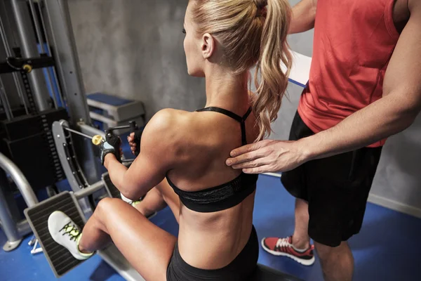 Hombres y mujeres flexionando los músculos en la máquina de gimnasio —  Fotos de Stock