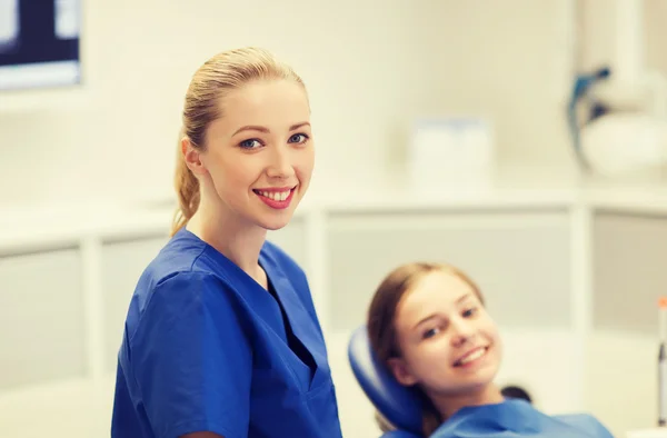 Felice dentista femminile con paziente ragazza in clinica — Foto Stock