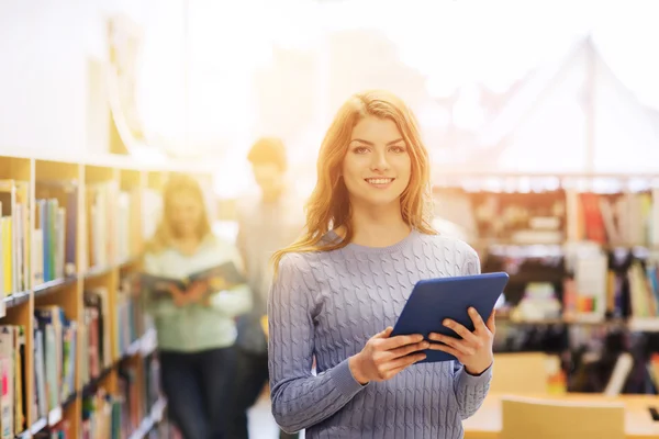 Lycklig student tjej med TabletPC i biblioteket — Stockfoto