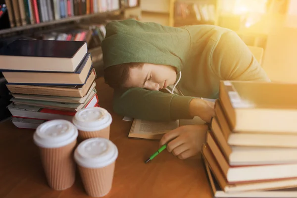 Zmęczony ucznia lub człowieka z książek w bibliotece — Zdjęcie stockowe