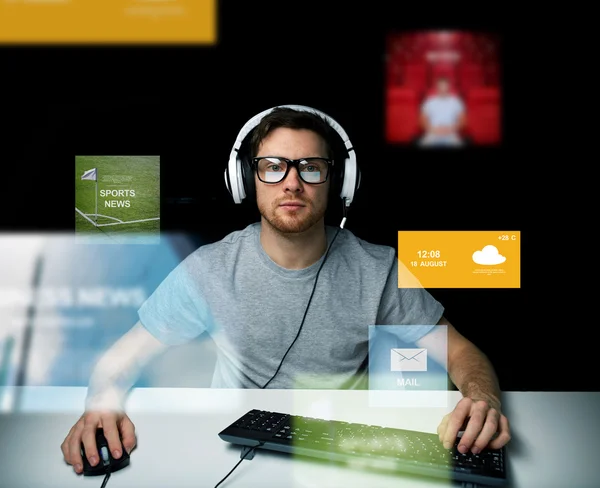 Man in hoofdtelefoon computer via virtuele media schermen — Stockfoto