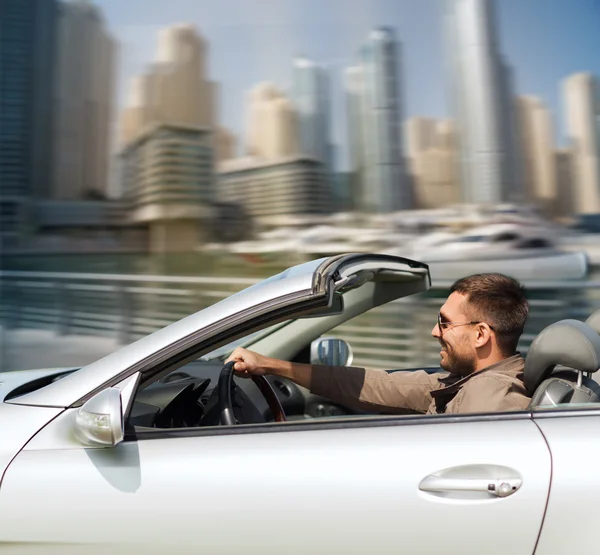 Hombre feliz conduciendo cabriolet coche en la ciudad — Foto de Stock