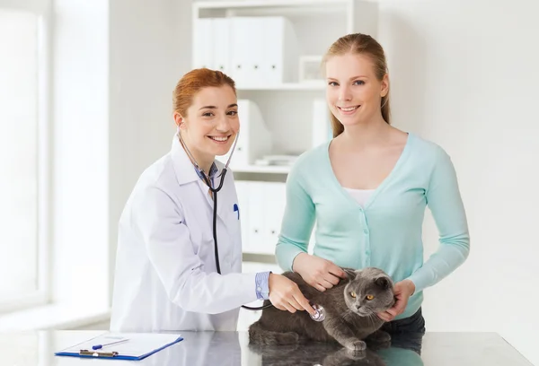 Happy woman with cat and doctor at vet clinic — Stock Photo, Image