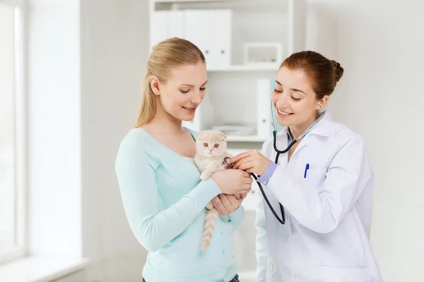 Mulher feliz com gato e médico na clínica veterinária — Fotografia de Stock
