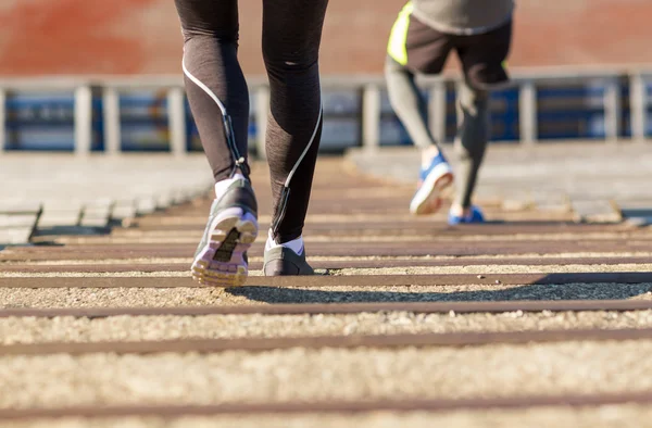 Close up of couple running downstairs on stadium — Stock Photo, Image