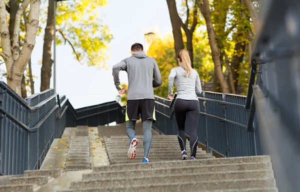 Pareja corriendo arriba en parque de la ciudad — Foto de Stock