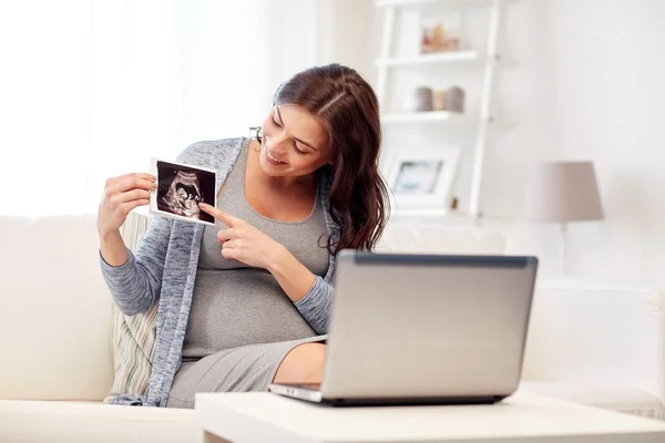 Happy pregnant woman with ultrasound image at home — Stock Photo, Image