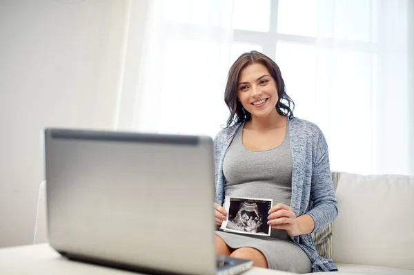 Happy pregnant woman with ultrasound image at home — Stock Photo, Image