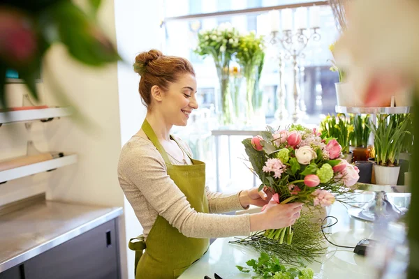 Souriant fleuriste femme faire tas à fleur boutique — Photo