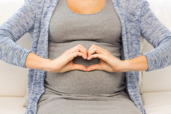 Primer plano de la mujer embarazada feliz haciendo corazón — Foto de Stock