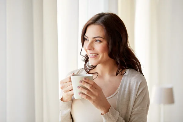 Mujer feliz con taza de té o café en casa — Foto de Stock