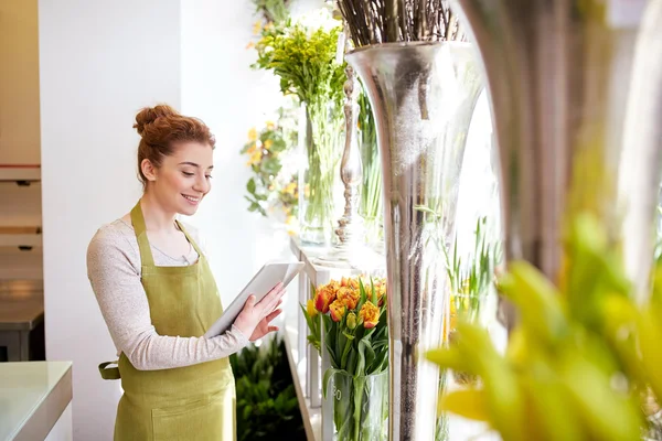 Жінка з планшетним комп'ютером у квітковому магазині — стокове фото