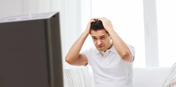 Disappointed man watching tv at home — Stock Photo, Image