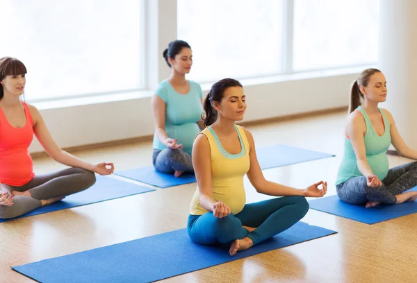 Mujeres embarazadas felices ejercitando yoga en el gimnasio —  Fotos de Stock