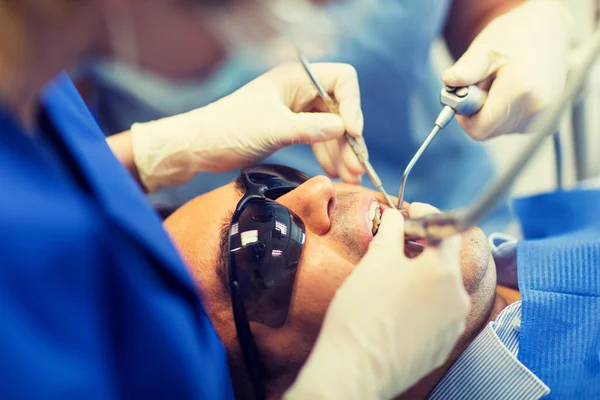 Primer plano de los dentistas que tratan los dientes en la clínica — Foto de Stock