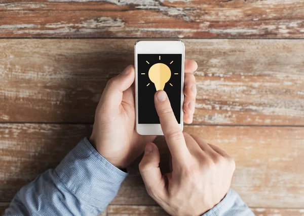 Close up of male hands with smartphone on table — Stock Photo, Image