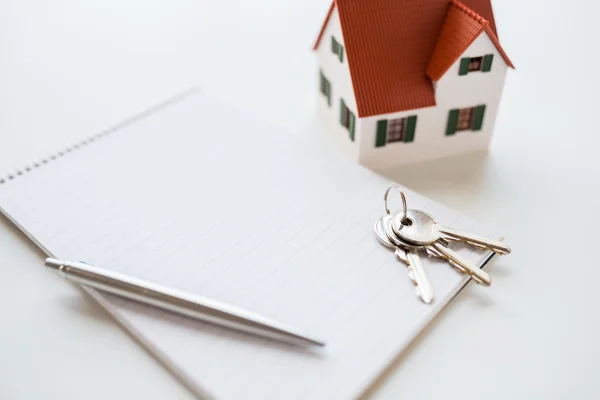 Close up of home model, house keys and notebook — Stock Photo, Image