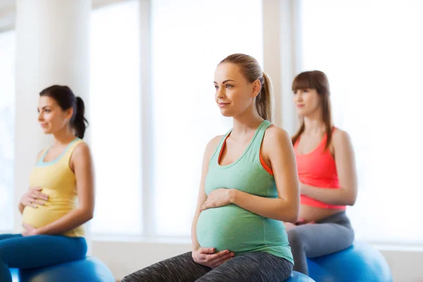 Šťastné těhotné ženy na fitball v tělocvičně — Stock fotografie