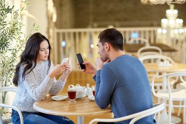 Casal com smartphones bebendo chá no café — Fotografia de Stock