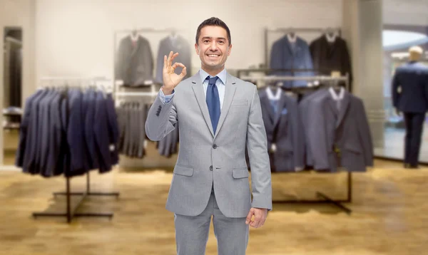 Felice uomo d'affari in giacca e cravatta sopra negozio di abbigliamento — Foto Stock