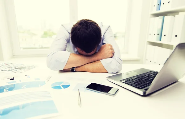 Geschäftsmann mit Laptop und Papieren im Büro — Stockfoto