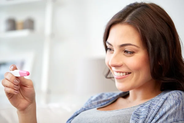 Szczęśliwa kobieta patrząc w domu test ciążowy — Zdjęcie stockowe