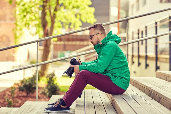 Hipster młody człowiek z cyfrowy aparat fotograficzny w mieście — Zdjęcie stockowe