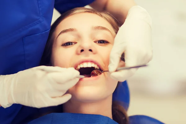 Dentista feminino verificando os dentes da menina paciente — Fotografia de Stock