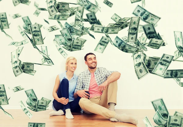 Casal feliz em casa sobre dólar dinheiro caindo — Fotografia de Stock